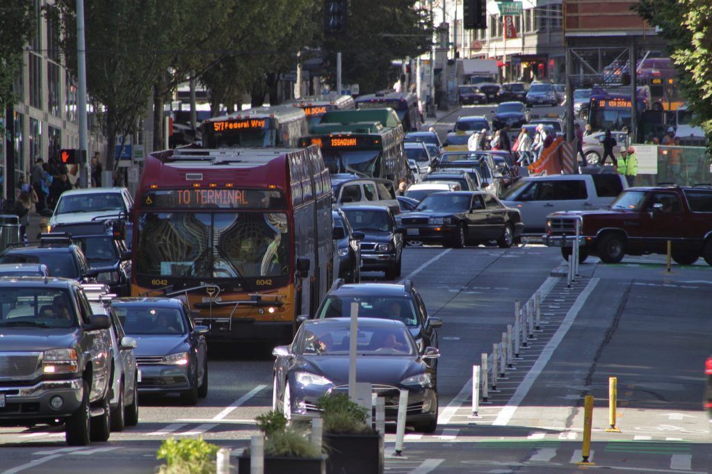 Metro busses navigate rush hour near downtown Seattle. The district has added thousands of jobs in recent years, but transit investments have kept single-rider car trips the same. Wikimedia photo by SounderBruce